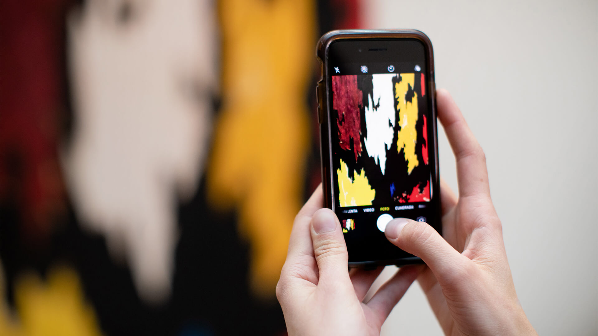 Woman takes a photo of a painting with her phone