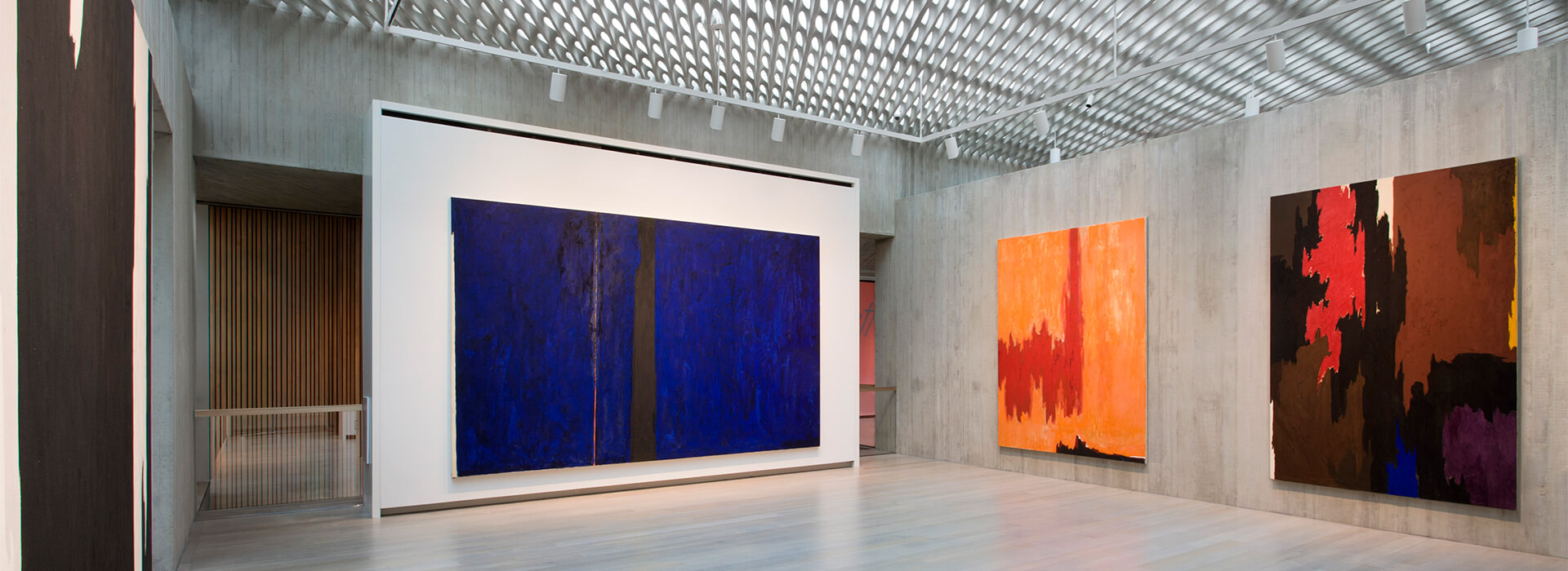 Empty gallery space with large colorful abstract paintings on the walls