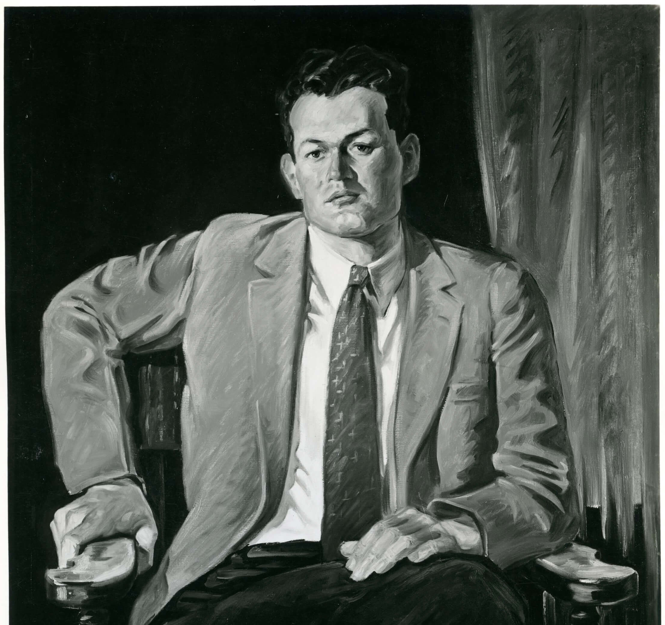 Portrait of a man with his jacket open, wearing a tie, and with one arm bent at a 90 degree angle to the side