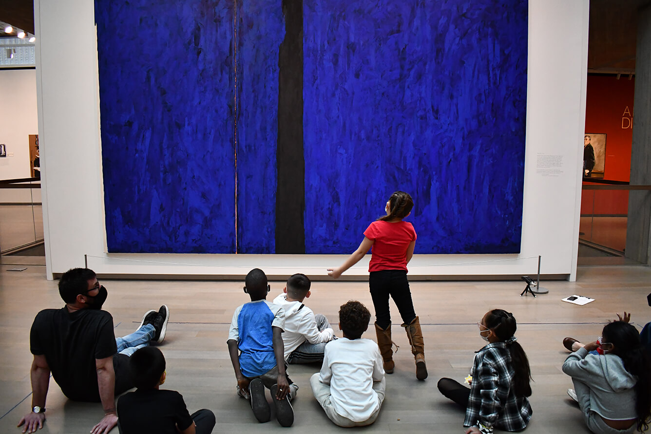 Students in front of a large abstract blue painting