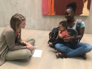 Senior Educator and Early Childhood Specialist Lisa Roll Moore models serve and return communication exchange with an Art Crawl participant and his mom.