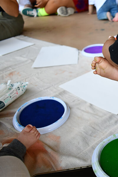 Babies putting their feet in paint