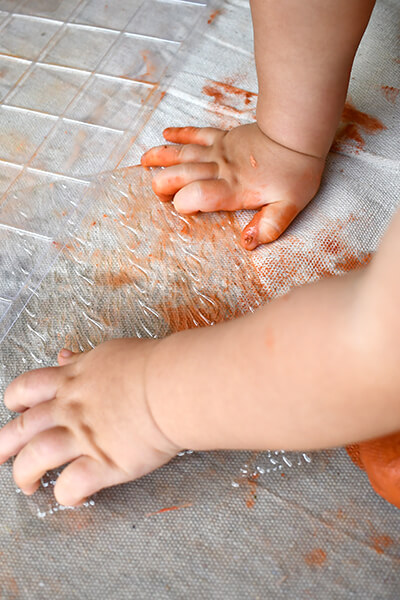 Two babies sets their hands down with clay on it
