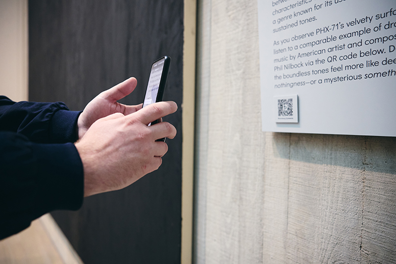 A person holds up their phone and scans a QR code