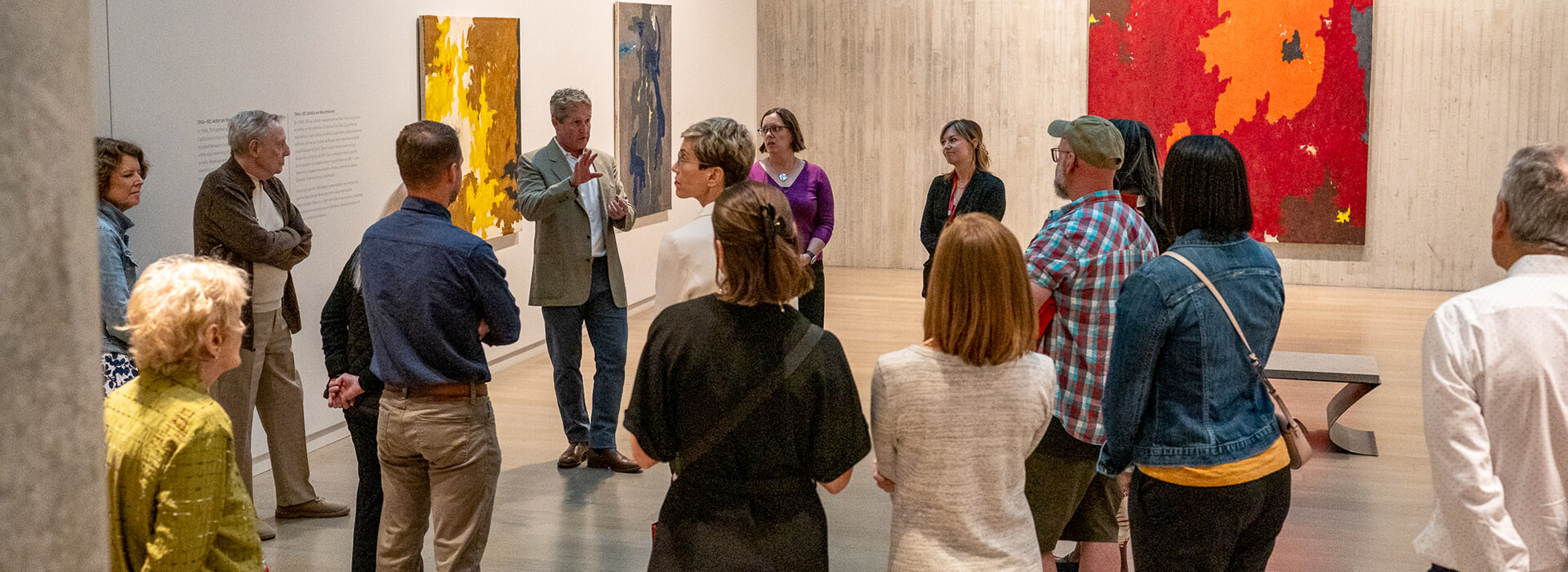 A group of people go on a tour in the Clyfford Still Museum galleries