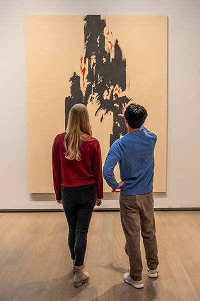 Two people look at a painting