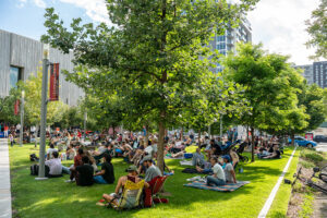 People sit on a lawn for a concert outside the Clyfford Still Museum