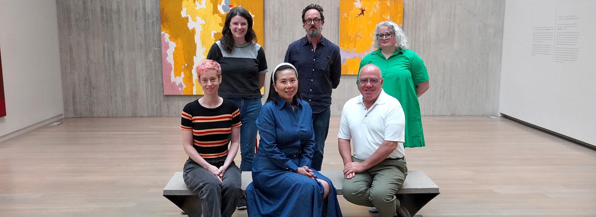 Group photo of people sitting and standing in a gallery