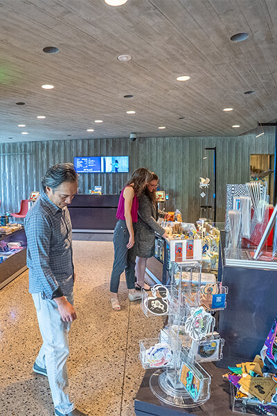 A group of three people look at merchandise in the Clyfford Still Museum Shop