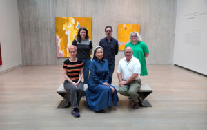 Group photo of people sitting and standing in a gallery