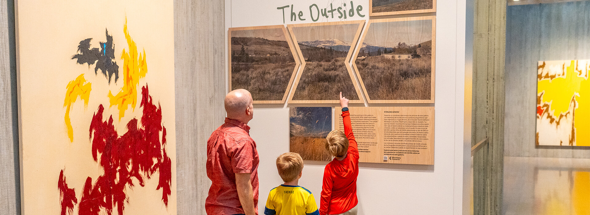 A boy points at a sign that says The Outside