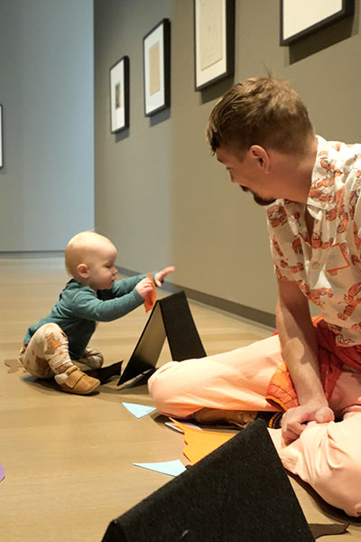 A dad looks at his baby while the baby plays with felt shapes
