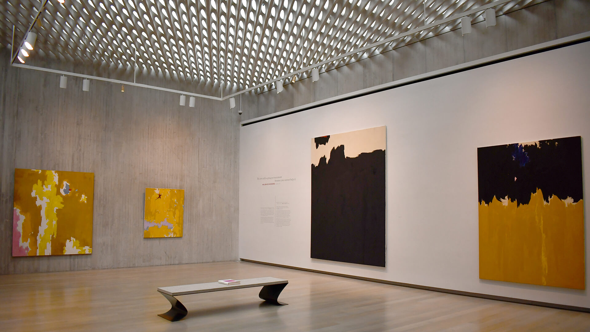 Empty gallery with large abstract yellow and black paintings