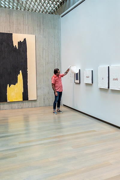 A man looks under a curtain in a gallery