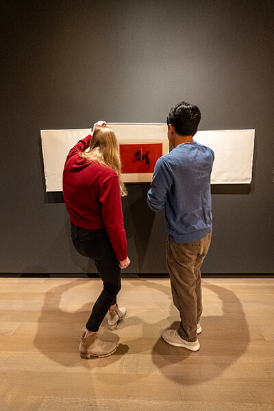 Two people look at an artwork