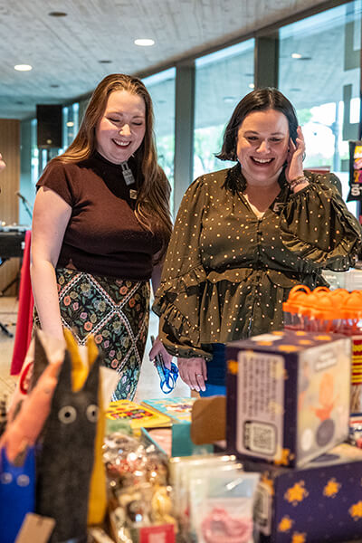 Two women looks at merchandise on a table at the Clyfford Still Museum Shop