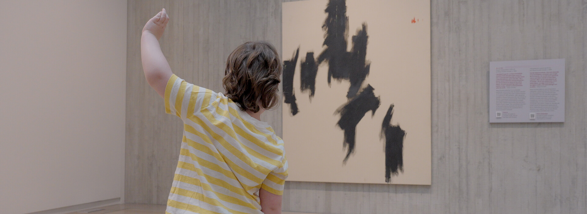 A young boy makes shapes he sees in a painting