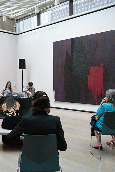 People listen to a performance in the galleries