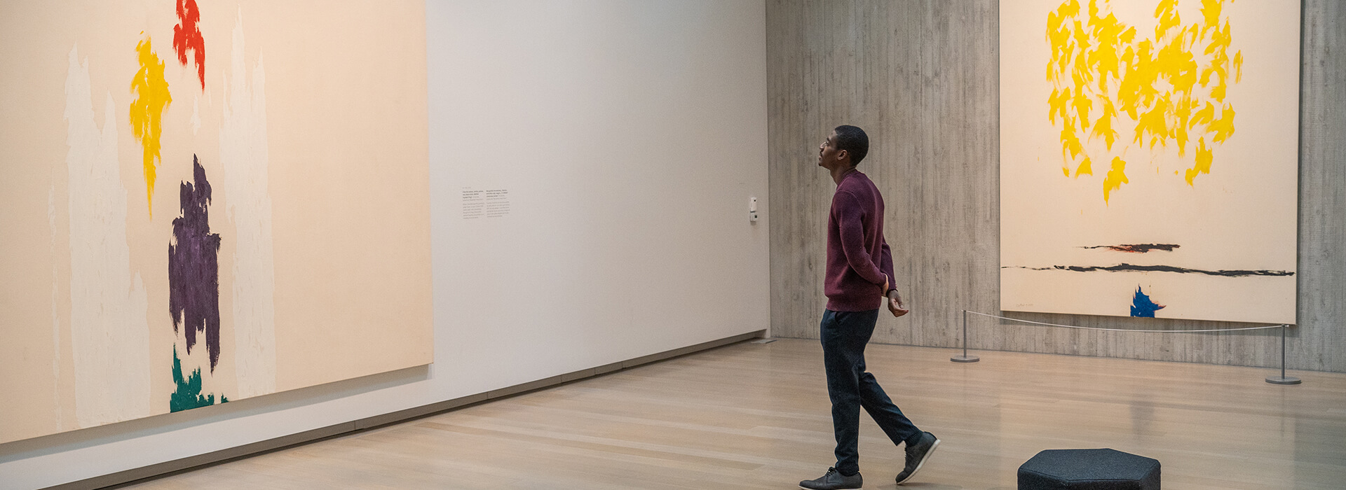 A man walks towards a colorful abstract painting