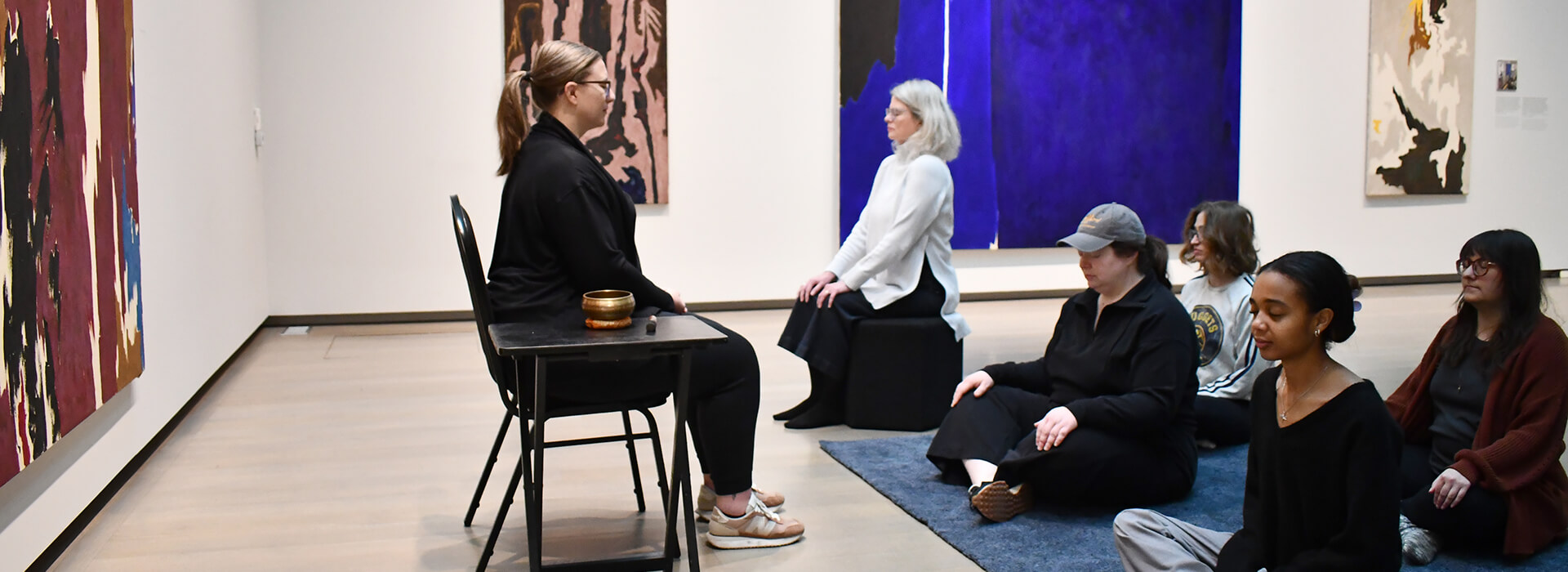 People meditating in a gallery