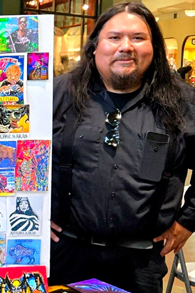 Artist Frank Andrews stands next to his sketches