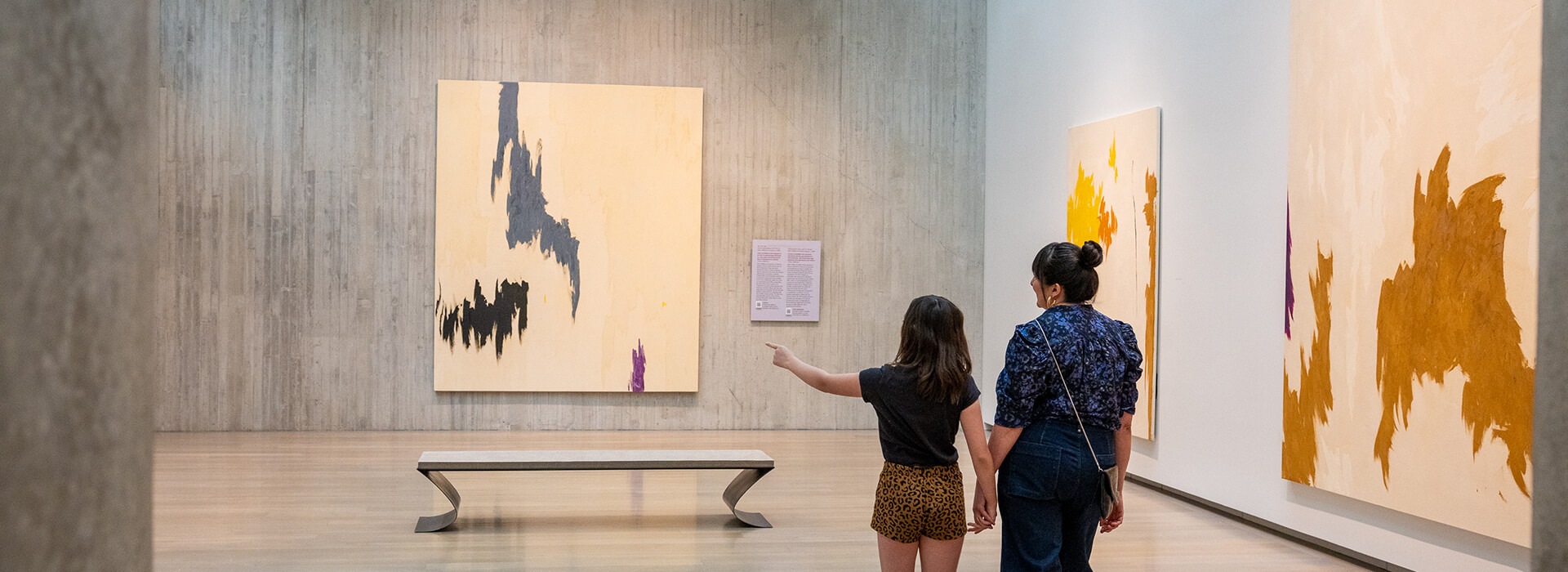 A mom and her daughter walk through a gallery at the Clyfford Still Museum