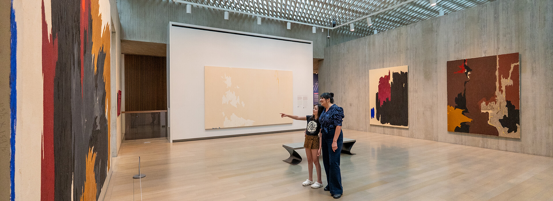 A child and her mom look at art