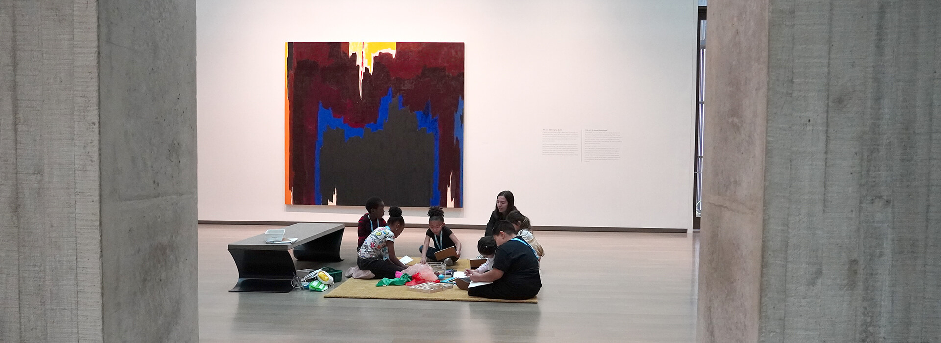 Students sit on a rug in a gallery