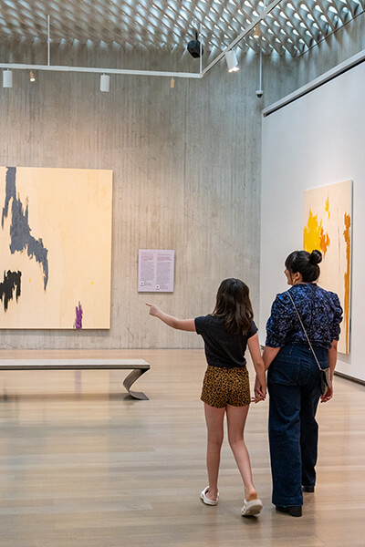 A mom and her daughter walk through a gallery at the Clyfford Still Museum