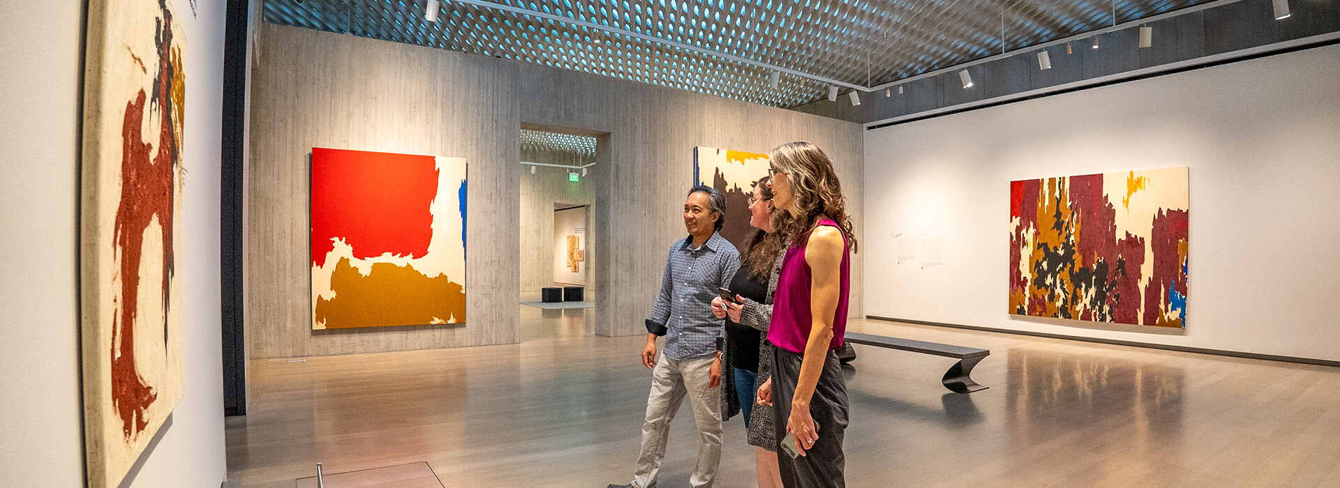 Three people look at art in the galleries