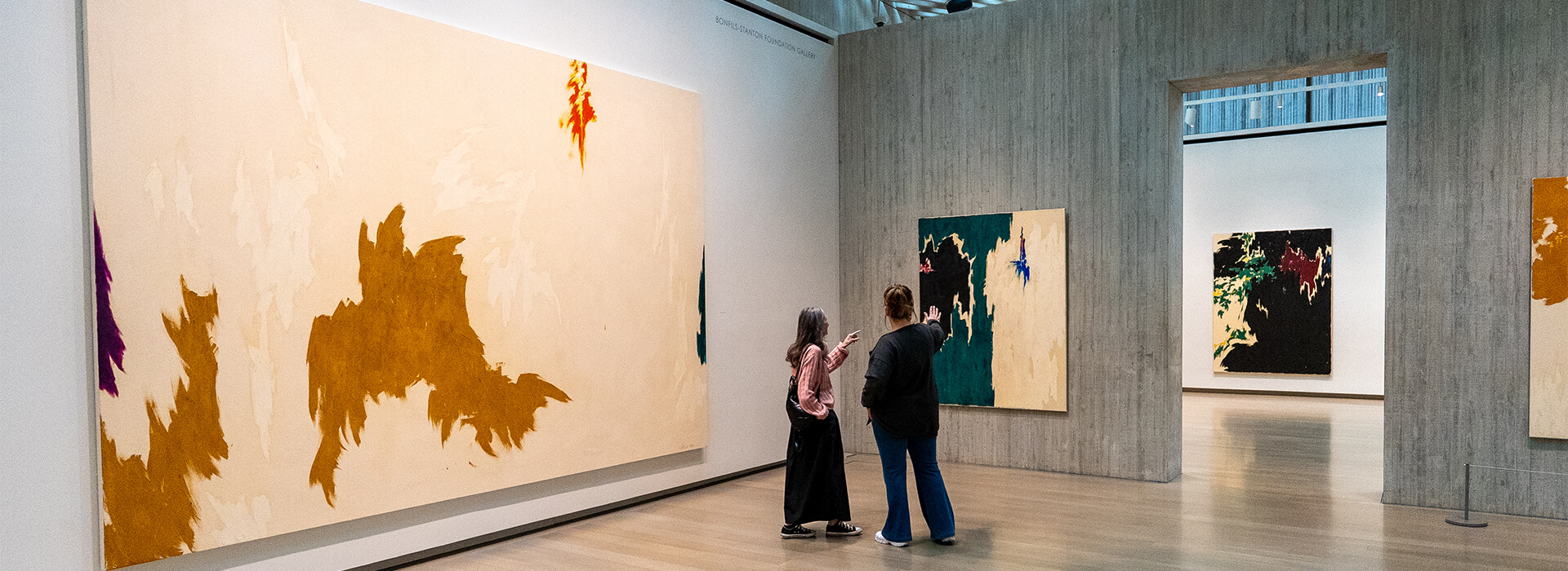 Two women look at an abstract painting