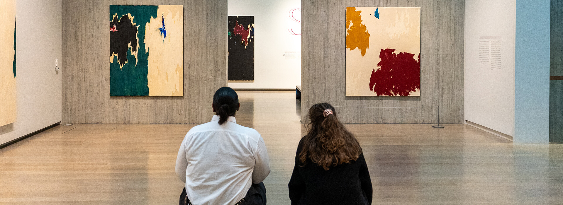 Two people look at a painting