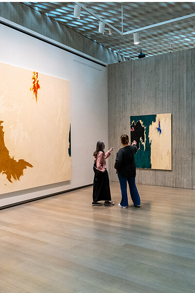 Two women look at an abstract painting