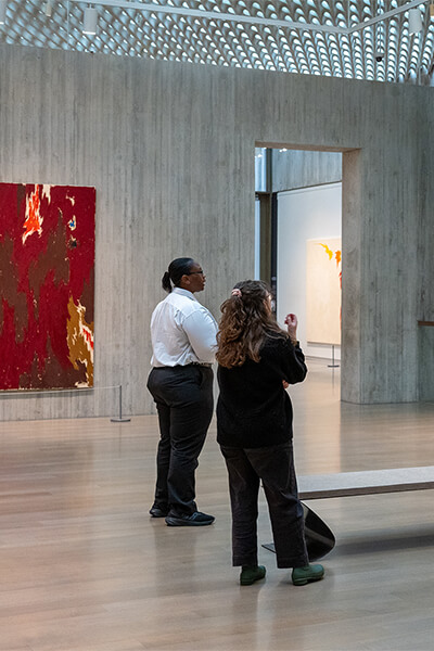 Two people look at art in a gallery