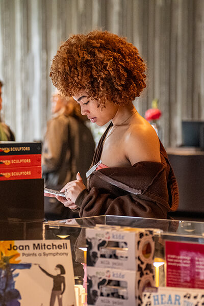 A young woman looks at items in the Clyfford Still Museum Shop