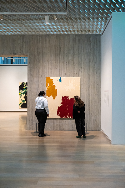 Two people look at a painting