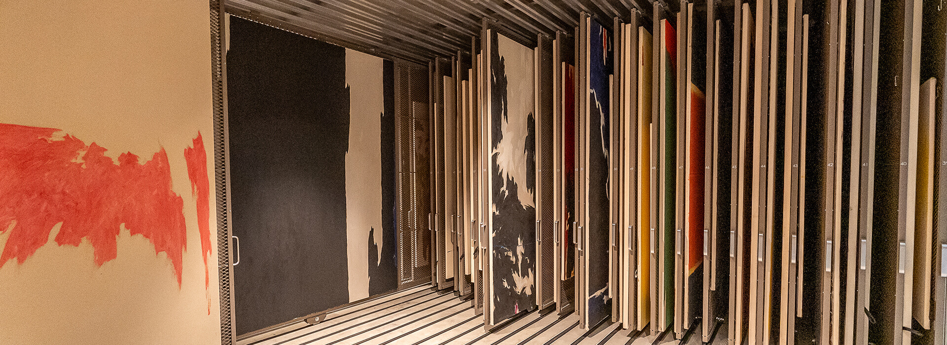 Stretched paintings on racks in storage