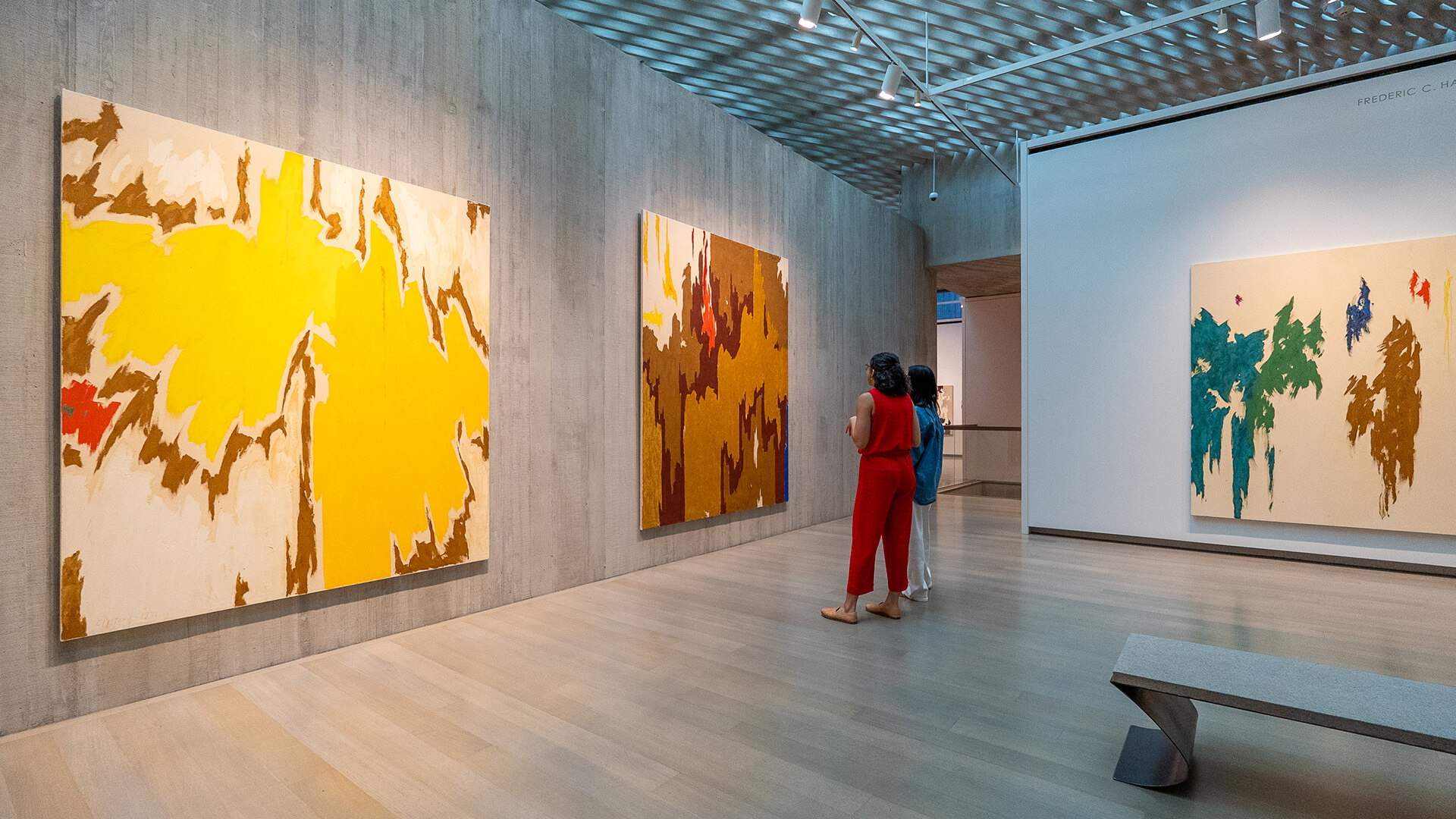 Two women look at an abstract painting in a gallery