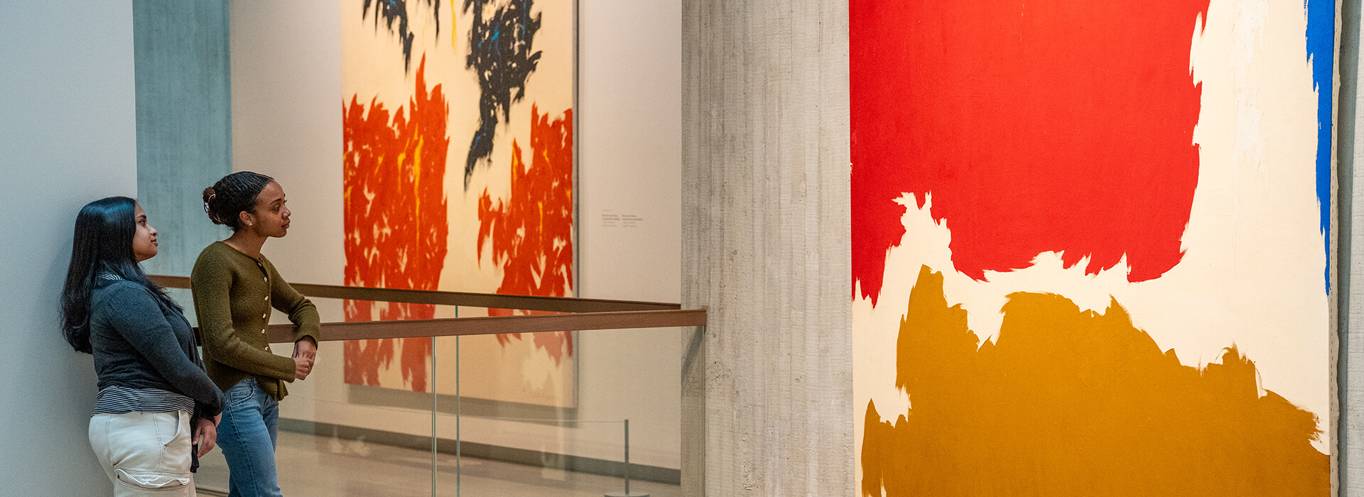 Two women look at an abstract painting