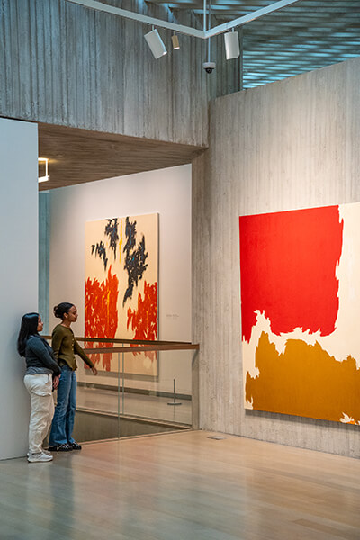 Two women look at an abstract painting