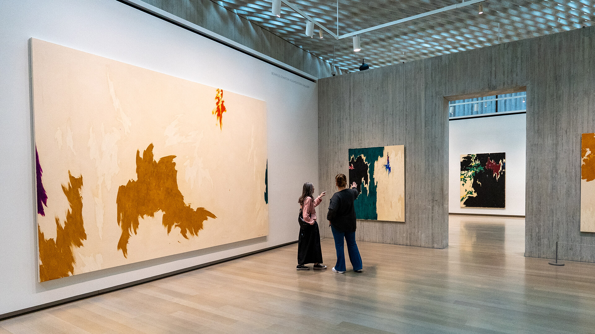 Two women look at a green painting