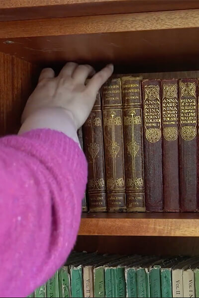 A member of the archives team reaches for a book in Still's library