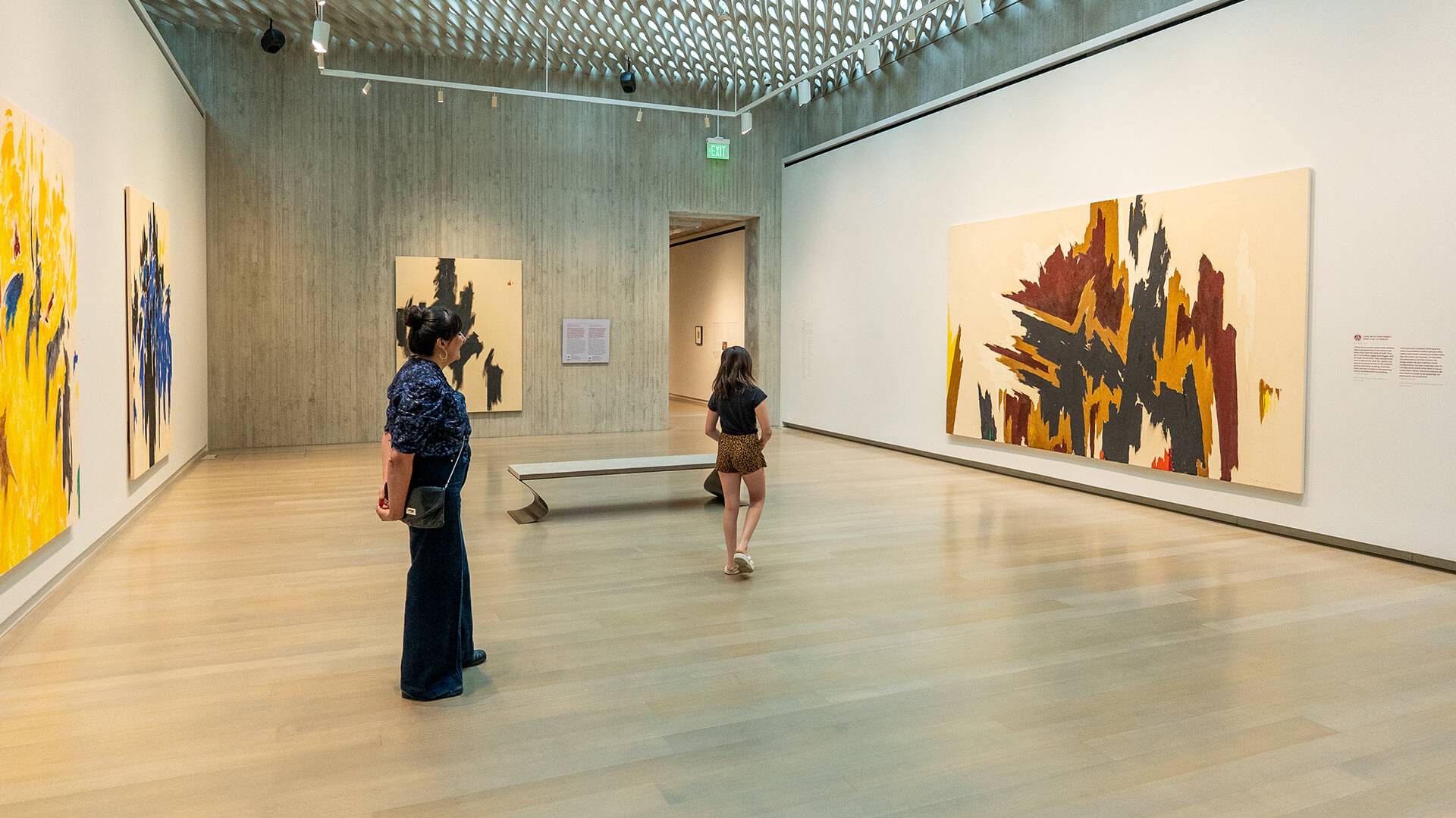 A mother and her daughter look at a large abstract painting