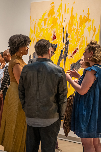 People talk in a gallery after hours